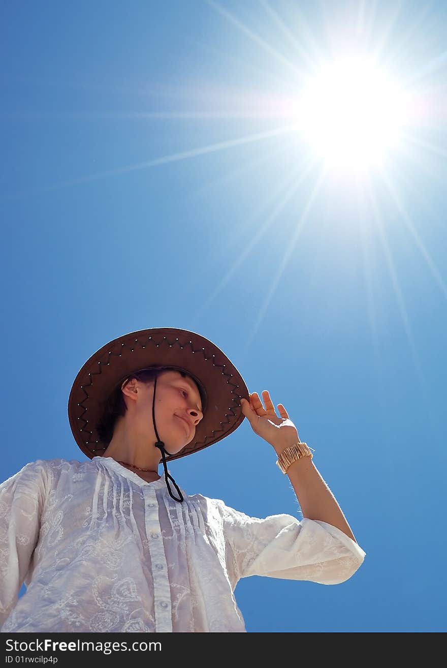 Beautiful young woman with hat on the sunny sky background. Beautiful young woman with hat on the sunny sky background