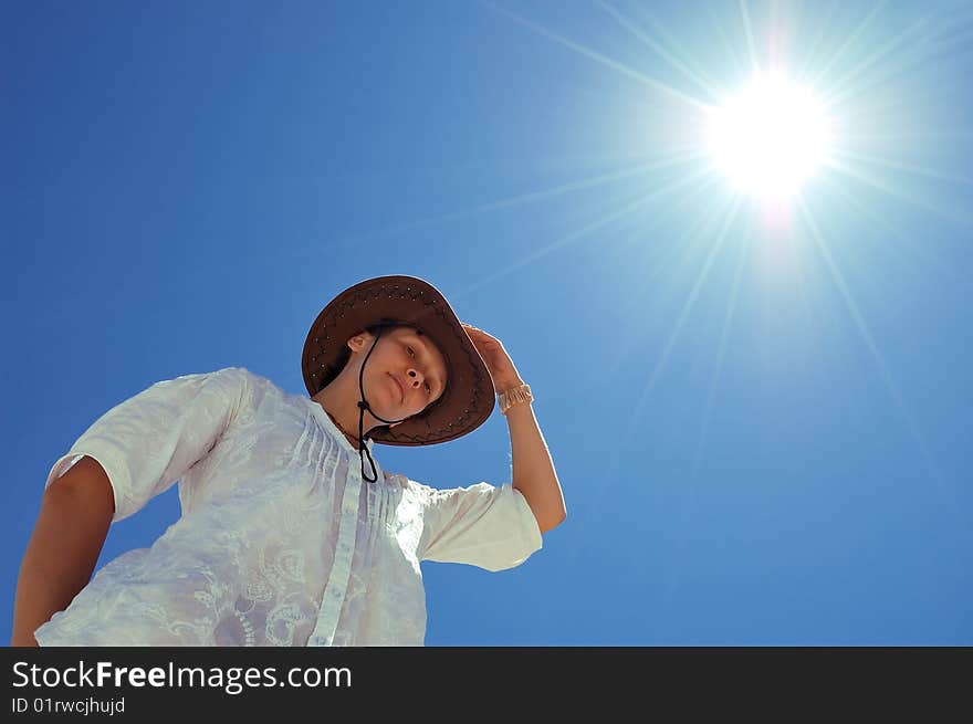 Beautiful young woman with hat on the sunny sky background. Beautiful young woman with hat on the sunny sky background