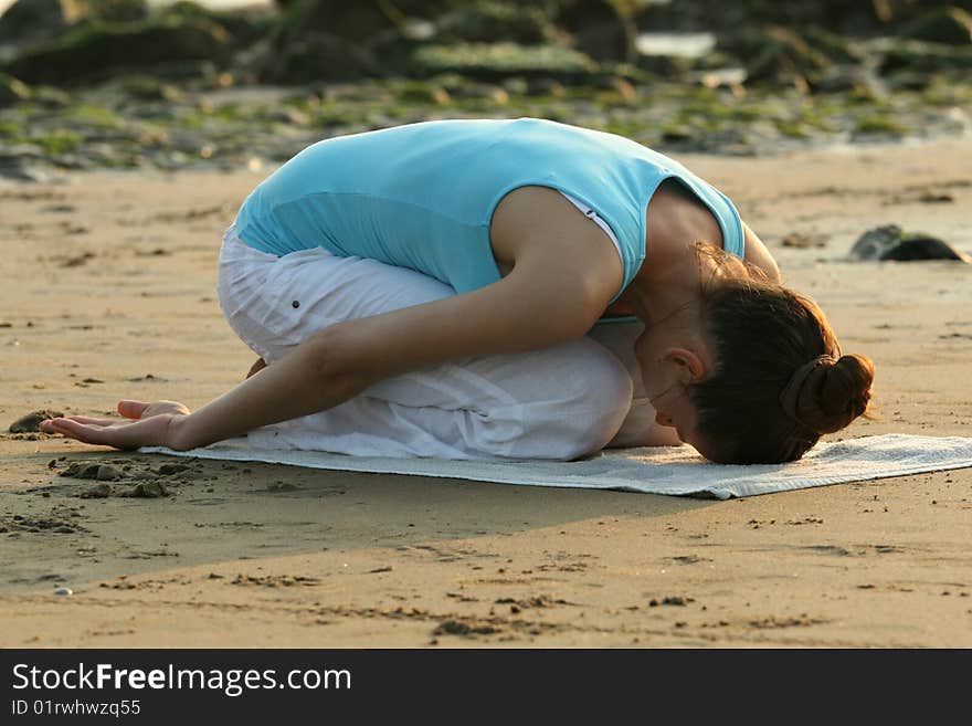 Woman doing yoga workout at the beach. Woman doing yoga workout at the beach