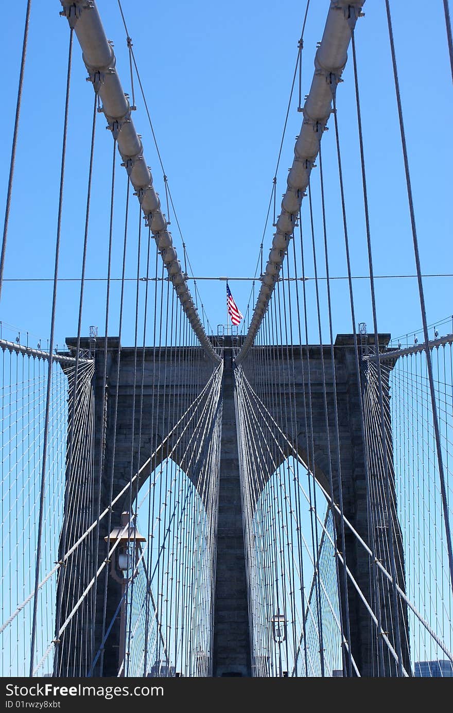 American flag waving over the Brooklyn Bridge