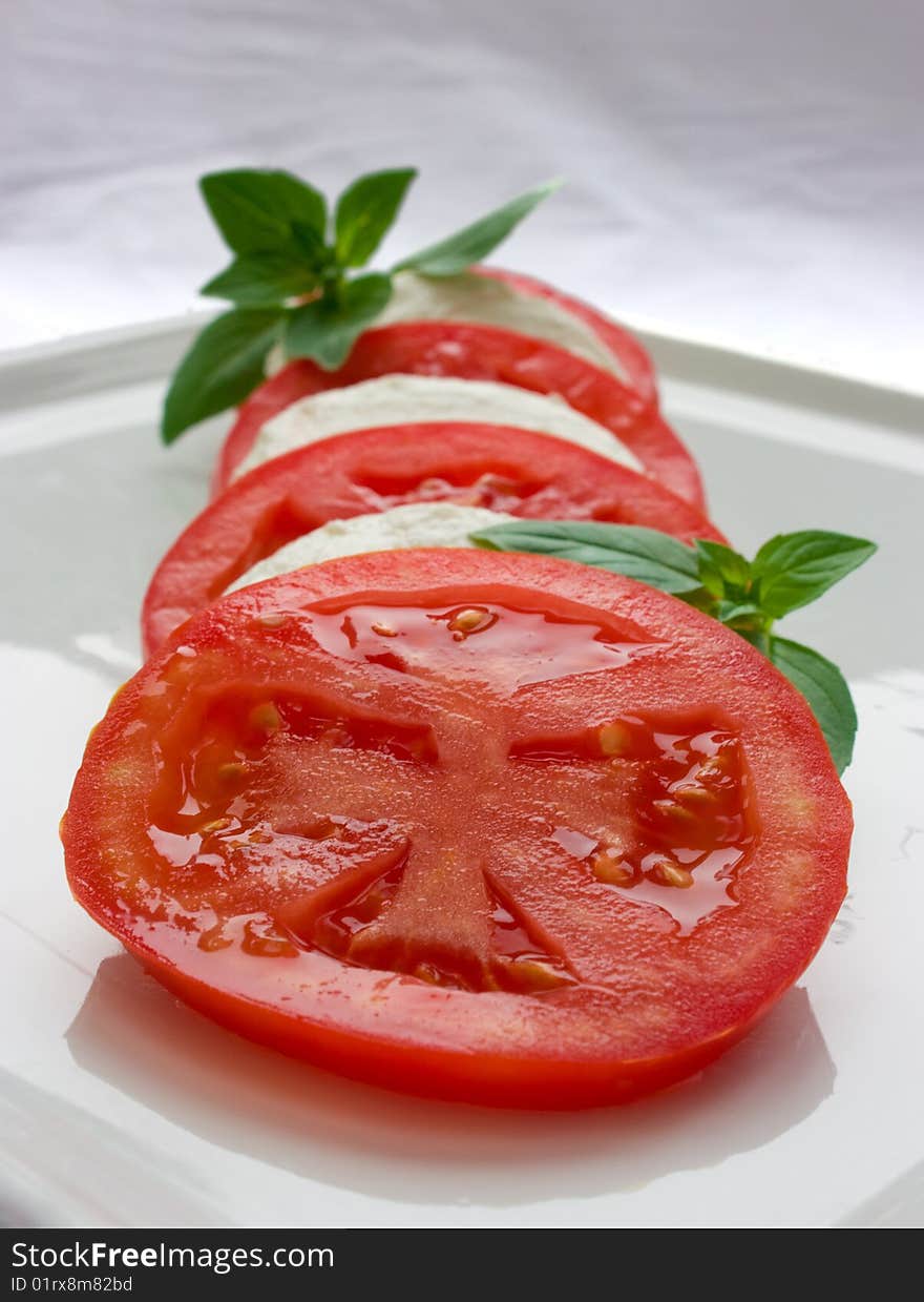 Tomato and cheese symmetrically arranged into salad. Tomato and cheese symmetrically arranged into salad