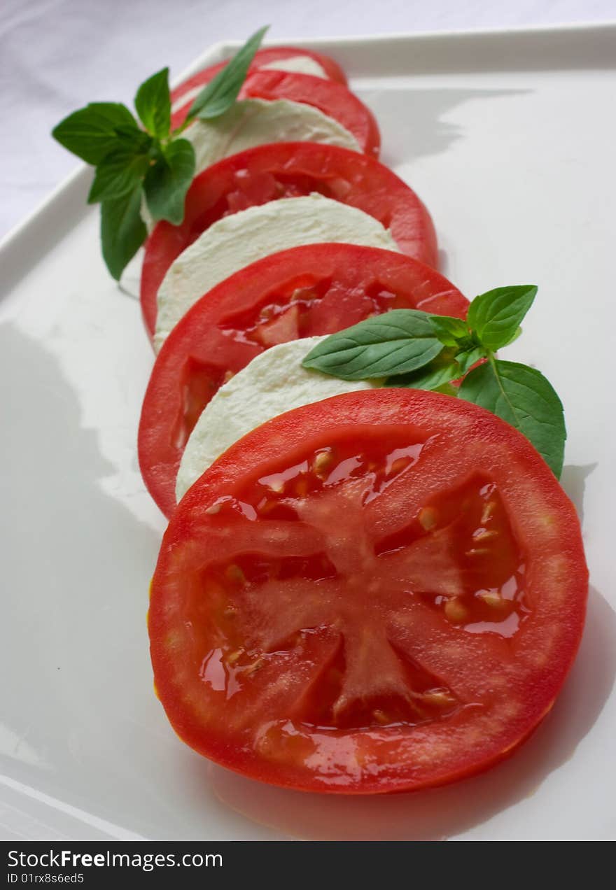 Tomato and cheese symmetrically arranged into salad. Tomato and cheese symmetrically arranged into salad