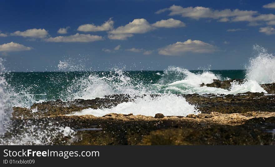 Sea waves break about stones