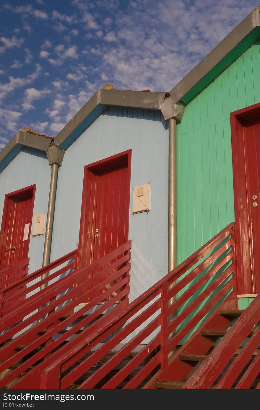 View of three colorful houses with red stairs, Tagus river. View of three colorful houses with red stairs, Tagus river.