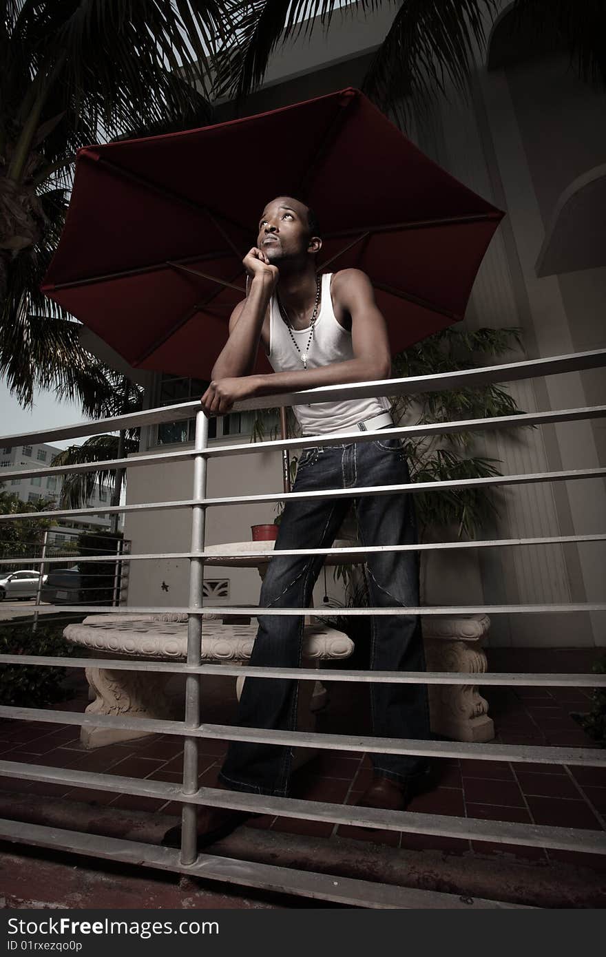 Man leaning on a rail thinking