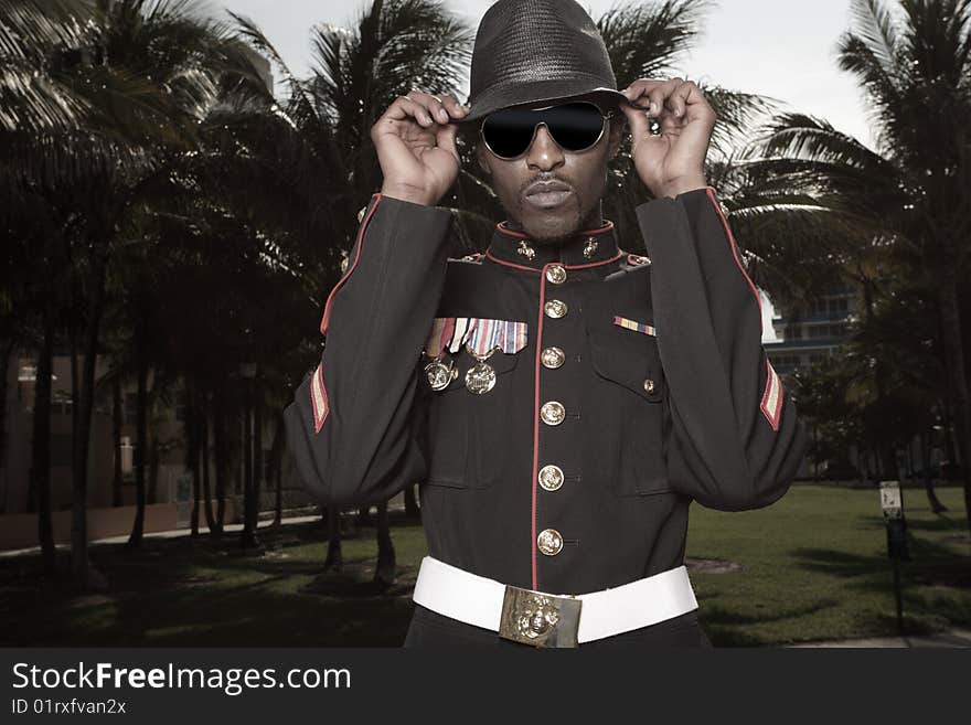 Fashionable model wearing a military jacket with a hat and sunglasses. Fashionable model wearing a military jacket with a hat and sunglasses