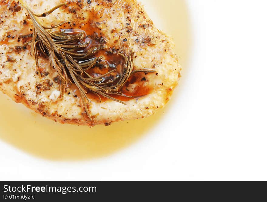 Rosemary chicken breast on a white plate with wood table background. Rosemary chicken breast on a white plate with wood table background.