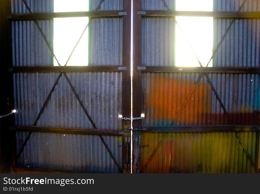 Light comes through the windows of two doors at a warehouse building. Light comes through the windows of two doors at a warehouse building.