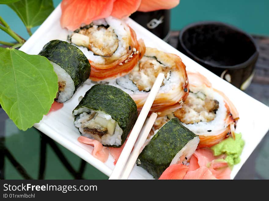 Sushi rolls  with chopsticks  and sake set close up. Sushi rolls  with chopsticks  and sake set close up