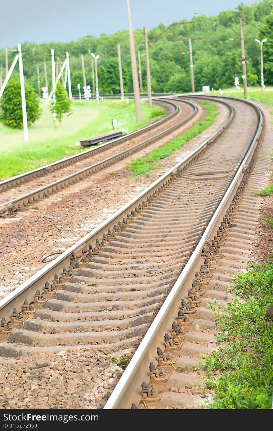 Railway bending around green wood. Railway bending around green wood