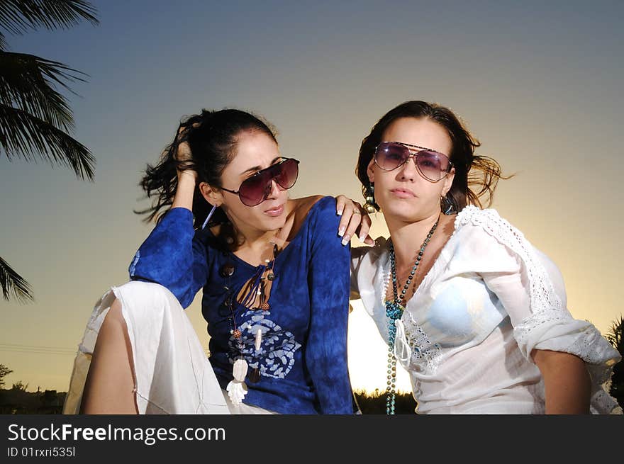 Portrait of two trendy young women on tropical sunset. Portrait of two trendy young women on tropical sunset