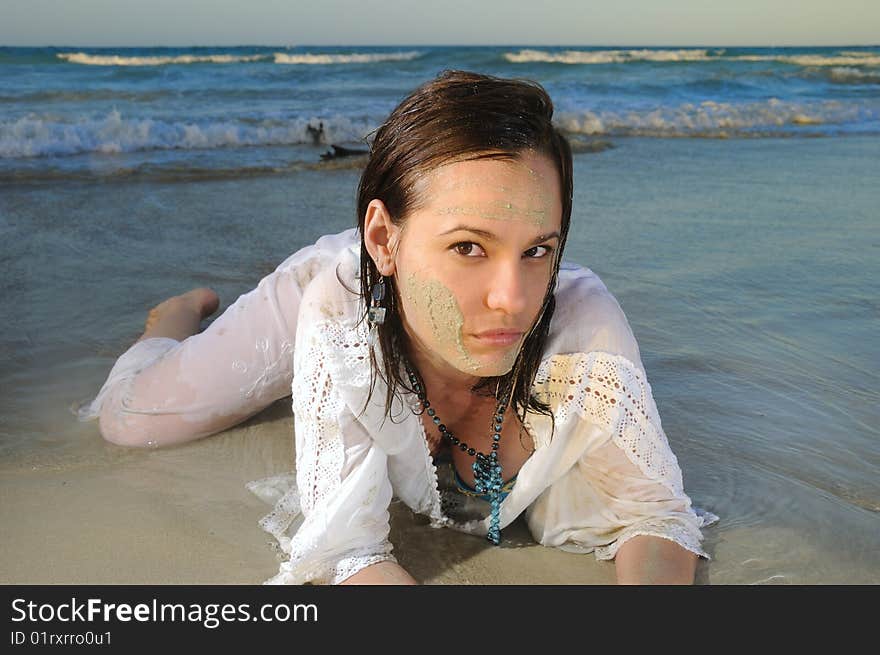 Portrait of young fashion woman lying on the sand of tropical beach. Portrait of young fashion woman lying on the sand of tropical beach