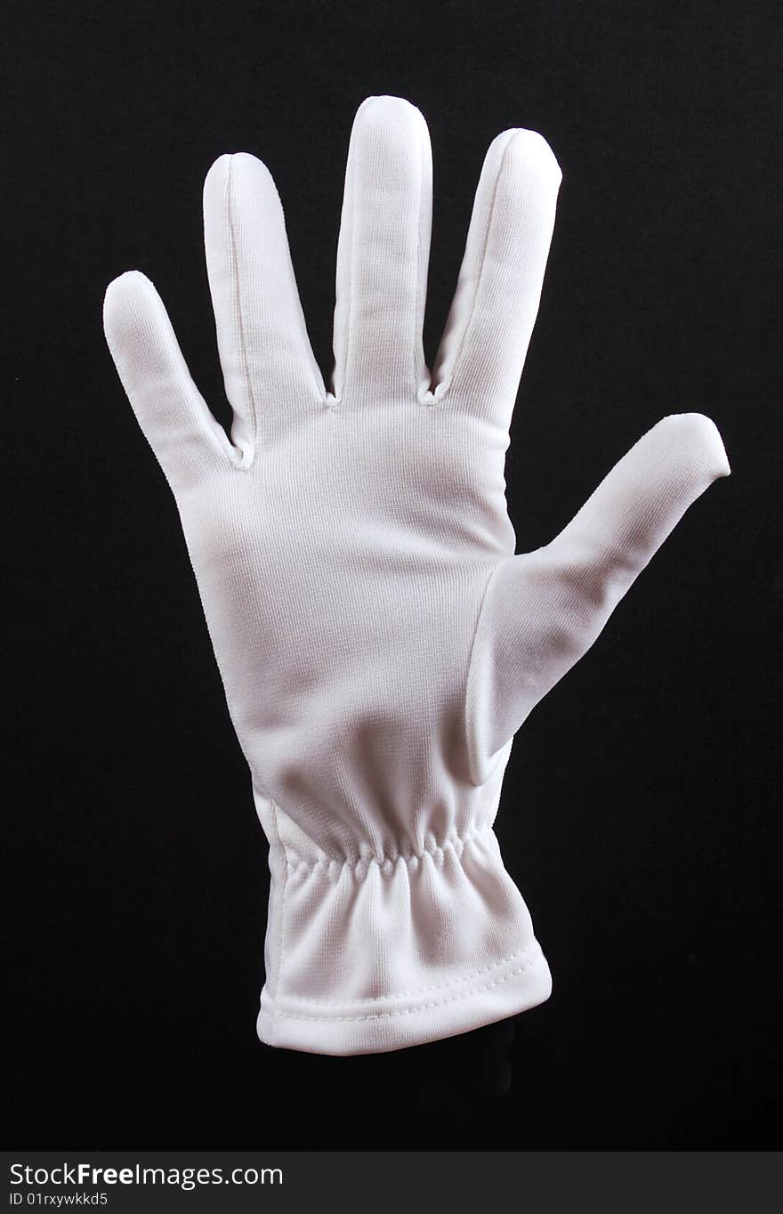 Open left hand in white glove on black background.