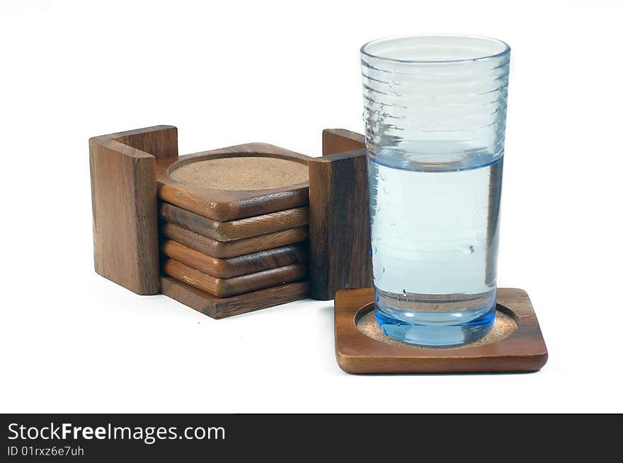 Wooden coasters, glass with water in it on a single coaster isolated on white. Wooden coasters, glass with water in it on a single coaster isolated on white