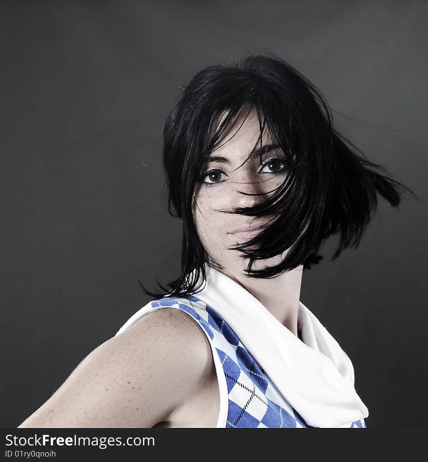 Portrait of young brunette woman waving hair