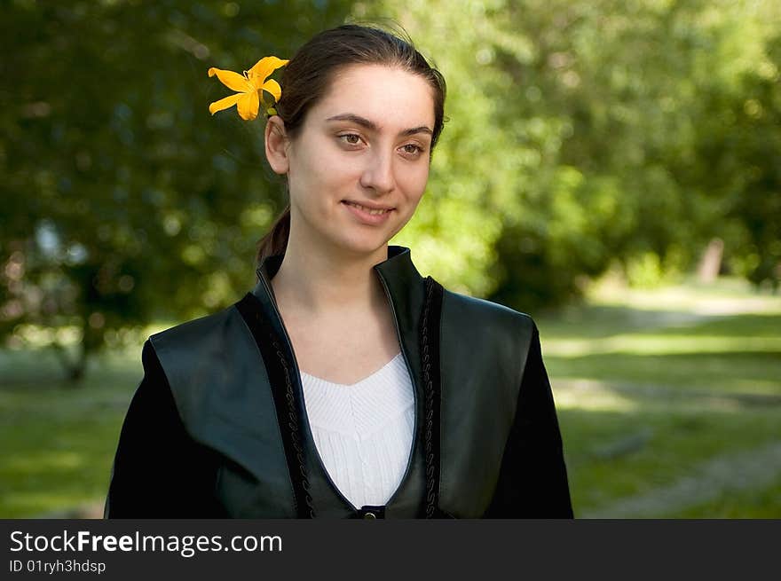 Young attractive woman in city park with flower in hair