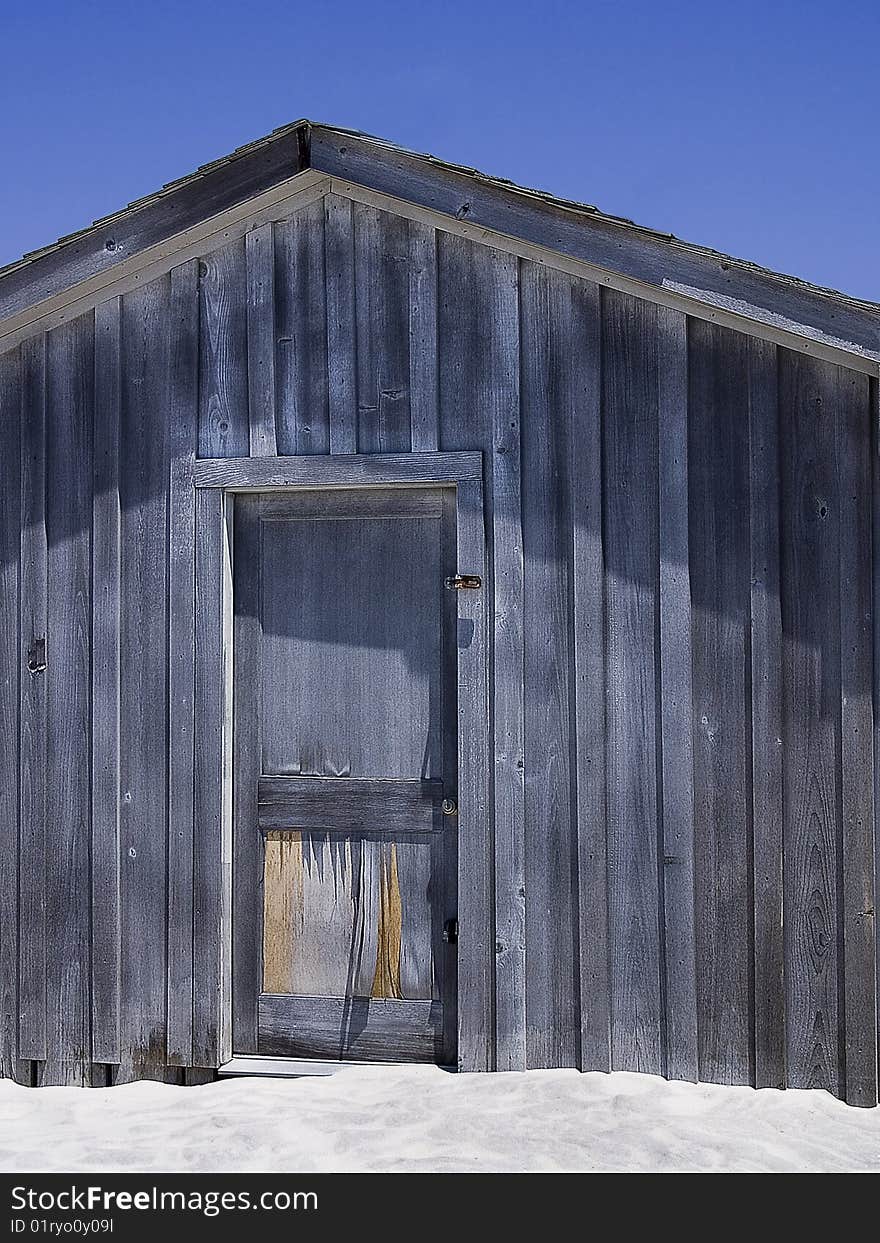 A shuttered up shack sits on a beach. A shuttered up shack sits on a beach