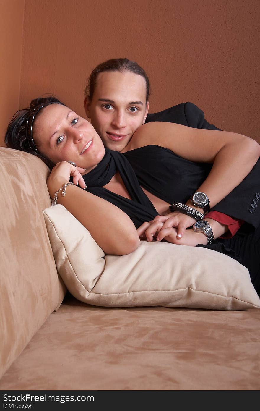 Young couple chilling on a couch at home. Both dressed up nicely. Young couple chilling on a couch at home. Both dressed up nicely.