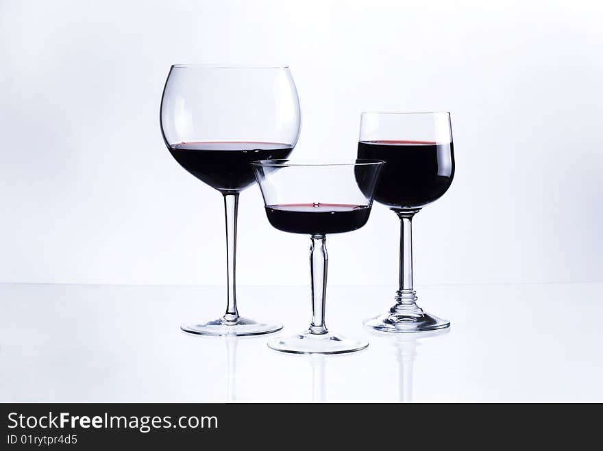 Three glasses with red wine on white background