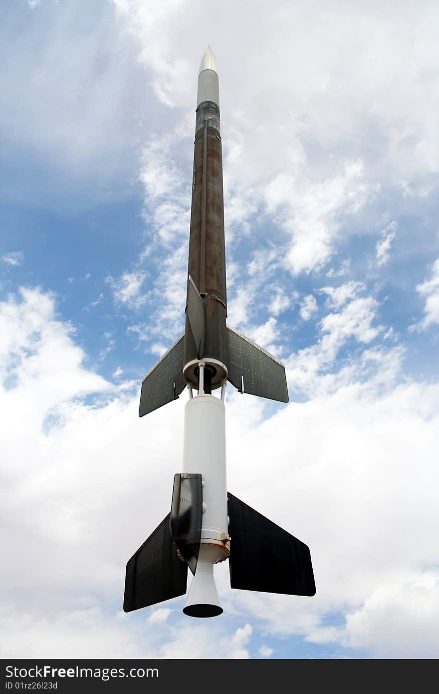 An Old Rocket Against a Cloudy Blue Sky