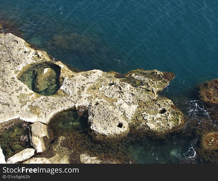 Stone beach with dark blue water half. Stone beach with dark blue water half