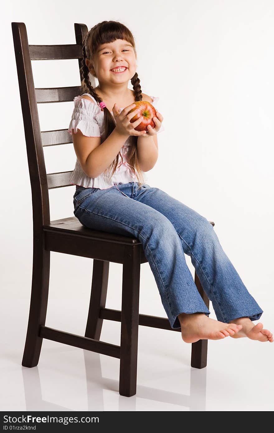 Photo of a girl with apple, sitting on a chair. Photo of a girl with apple, sitting on a chair