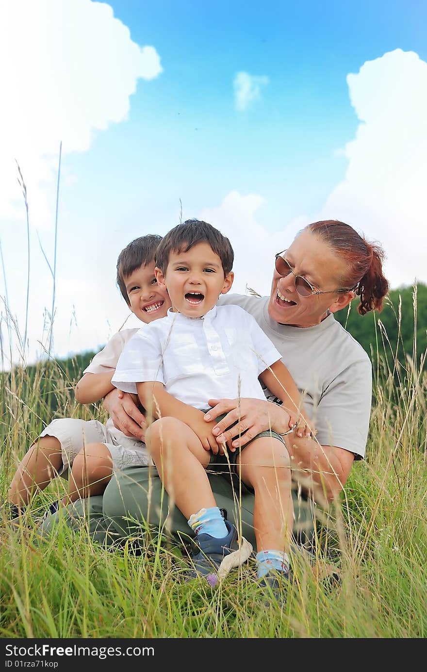 Happy Three Children In Nature With Grandmother