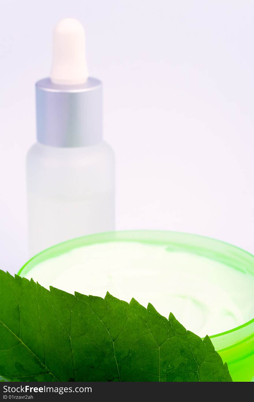 Cosmetic products with green leaf on white background