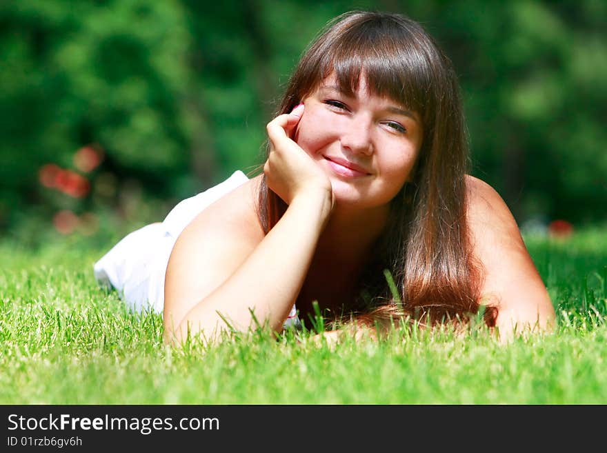 Happy girl laying in green grass