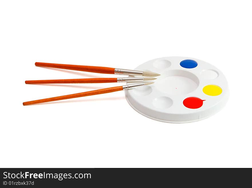 Round palette with three paintbrushes isolated