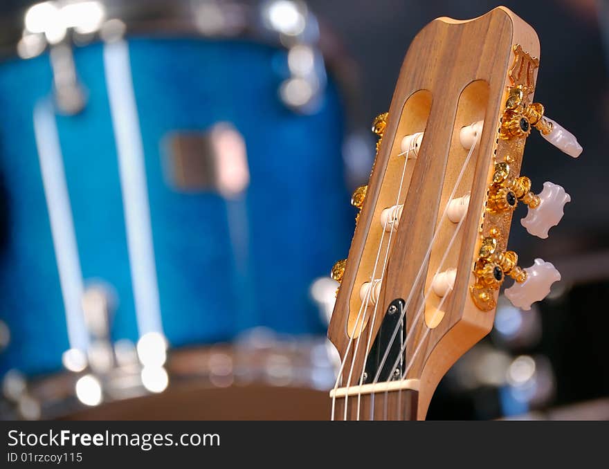 Headstock of guitar against drum.