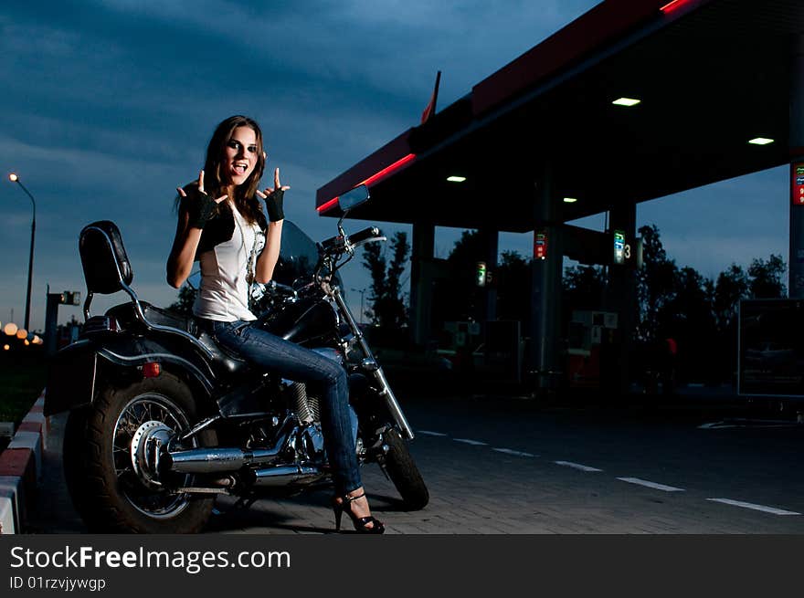 Model on the motorcycle on gas station, night shot. Model on the motorcycle on gas station, night shot