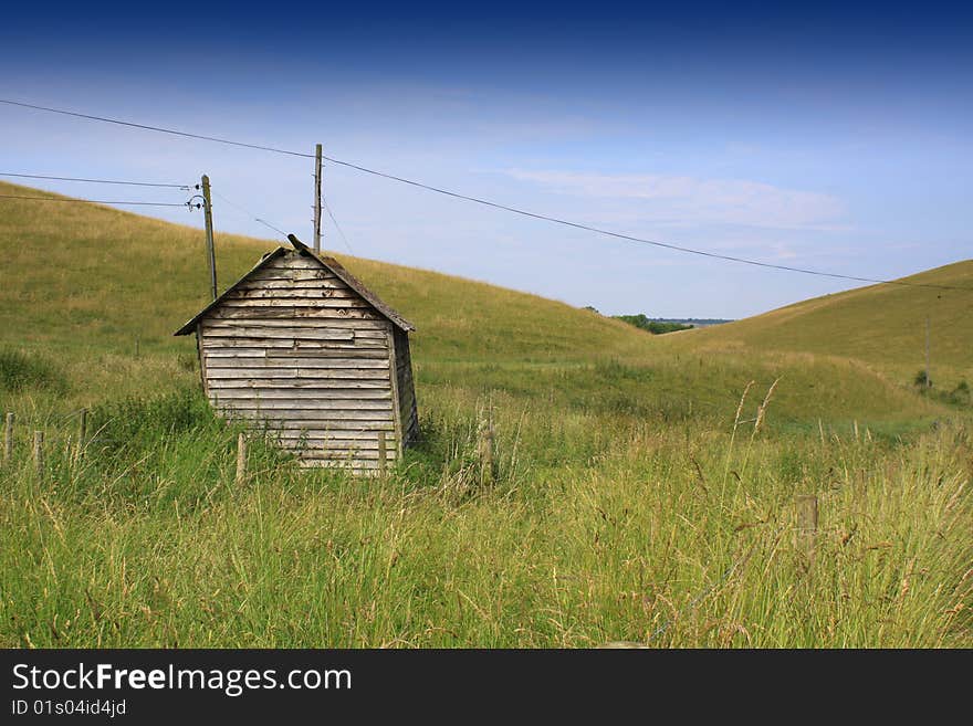 An isolated wooden hut set in a rural valley landscape in Wiltshire, England. An isolated wooden hut set in a rural valley landscape in Wiltshire, England.