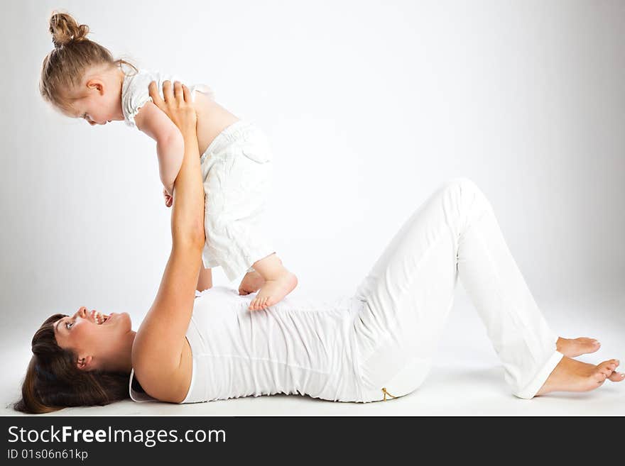 Mother and her little daughter. Gray background