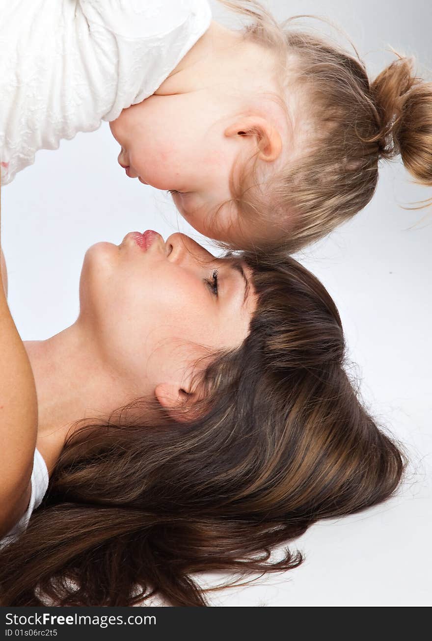 Mother and her little daughter. Gray background