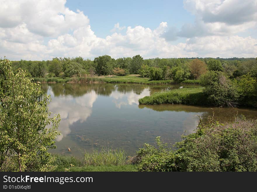 In a silent smooth surface of lake clouds are reflected. In a silent smooth surface of lake clouds are reflected