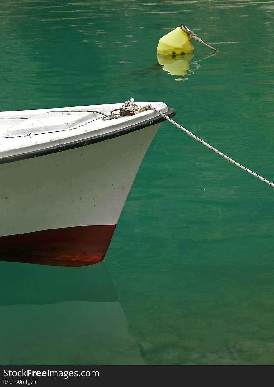 Yellow beacon and boat on green sea