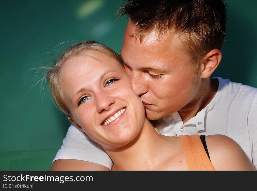 Young man kissing young woman on neck. Young man kissing young woman on neck