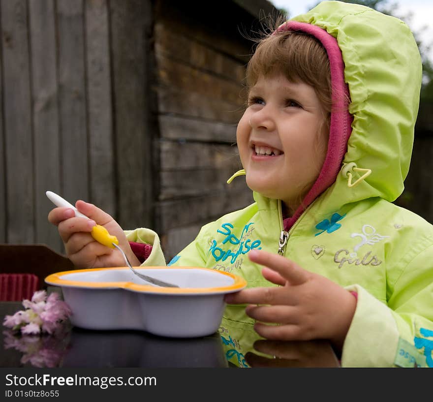 Little nice girl eating outdoors