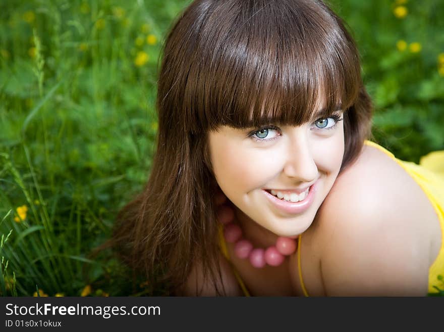 Young beautiful woman lays on green grass