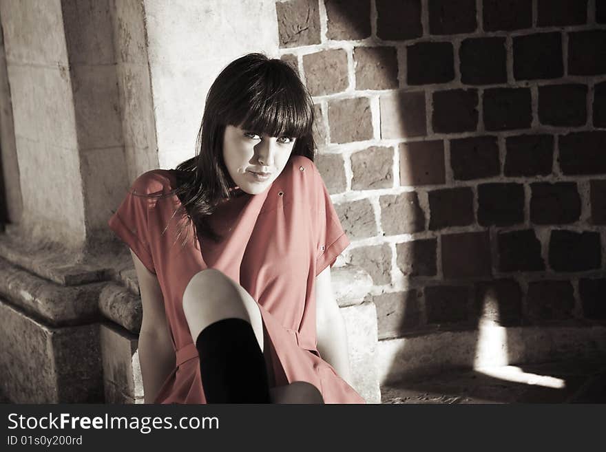 Beauty Woman Sitting Against Brick Border. Urban People Collection. Beauty Woman Sitting Against Brick Border. Urban People Collection.