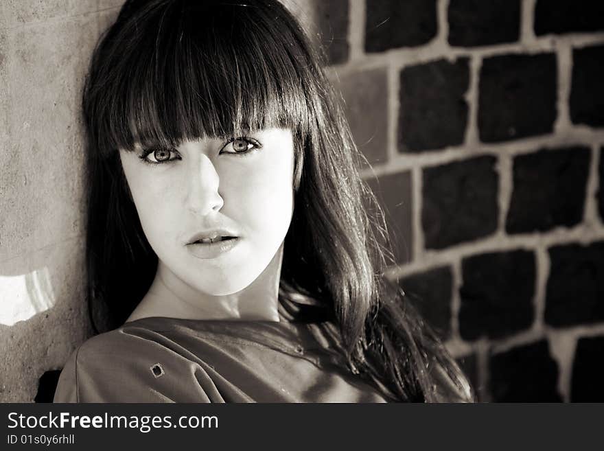 Portrait Om Beauty Woman Sitting against Brick Wall. Portrait Om Beauty Woman Sitting against Brick Wall