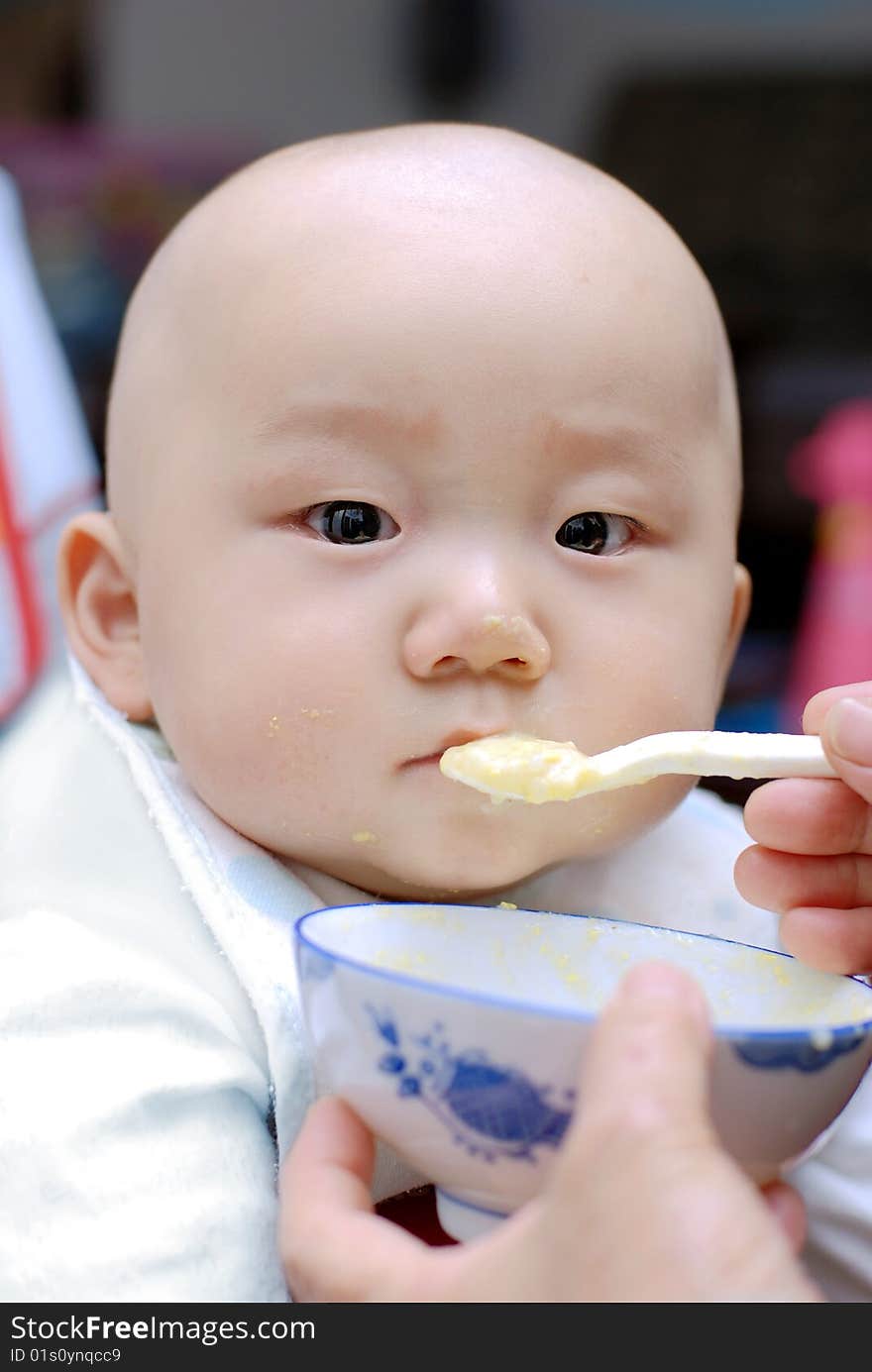 Baby with a spoon in a mouth. Baby with a spoon in a mouth