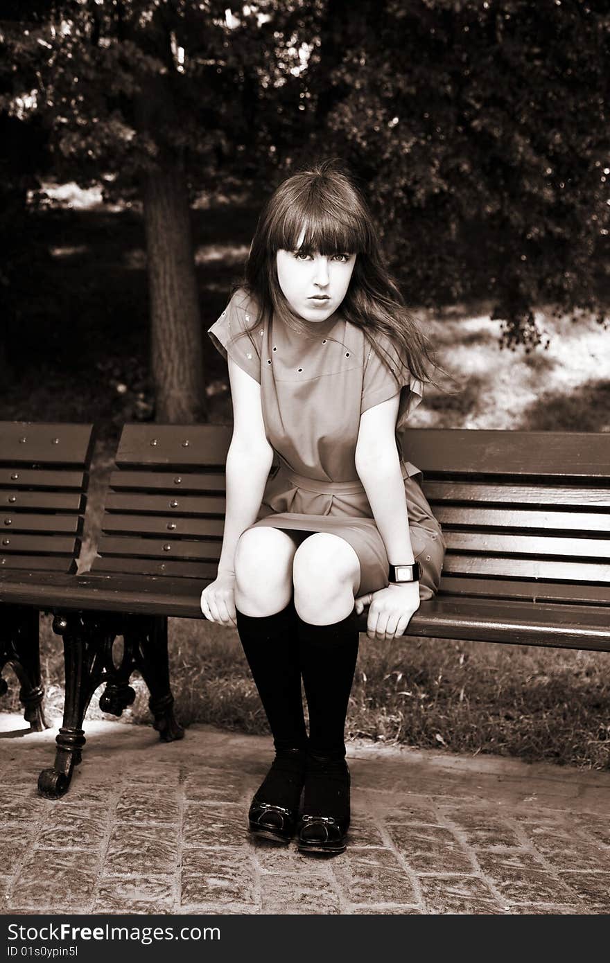 Young Beauty Woman Sitting On A Park Bench. Young Beauty Woman Sitting On A Park Bench