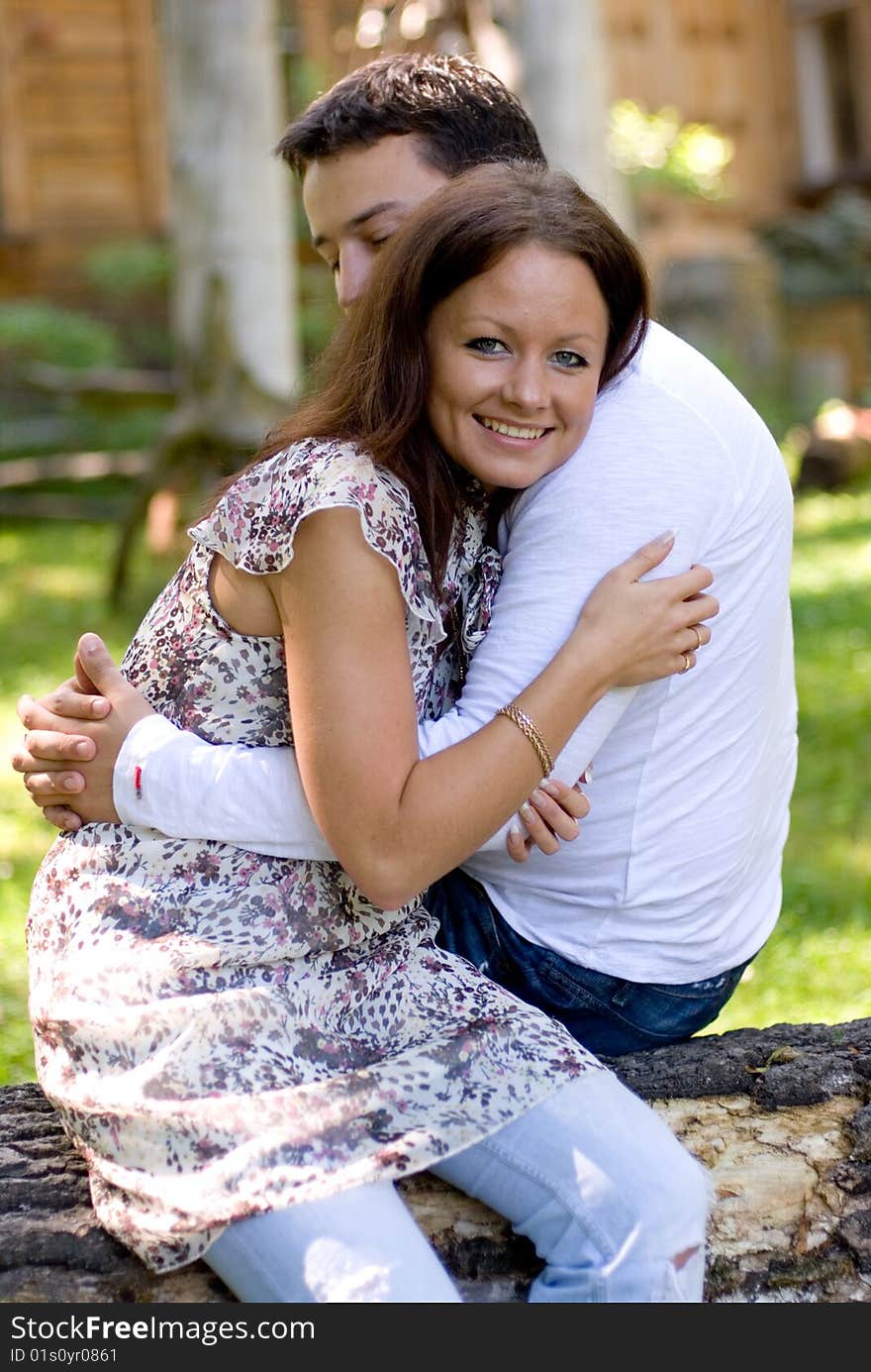 Woman with man sit on a tree to embrace each other. Woman with man sit on a tree to embrace each other