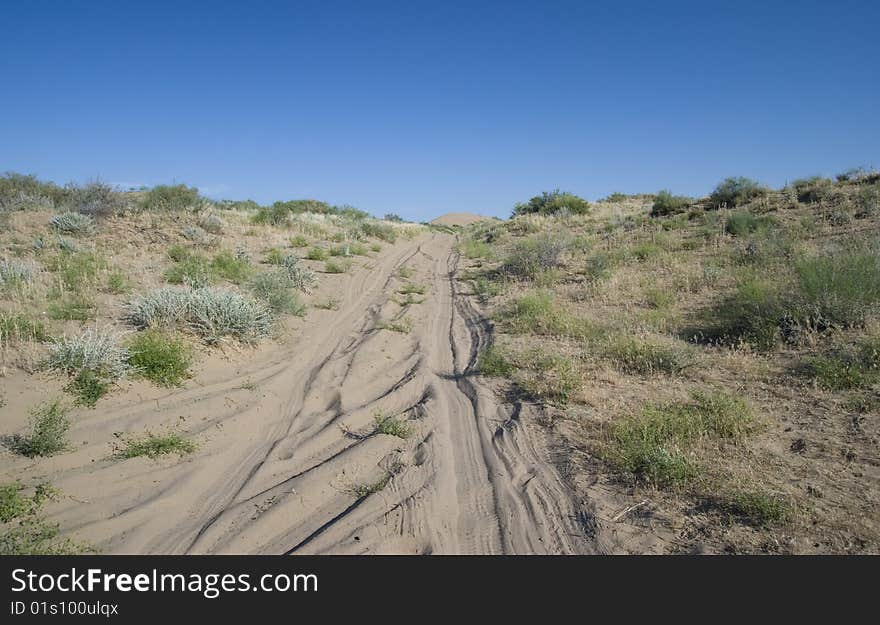 Road through the desert under a blue sky. Road through the desert under a blue sky