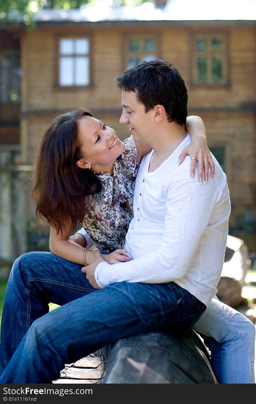 Woman with man sit on a tree to embrace each other. Woman with man sit on a tree to embrace each other