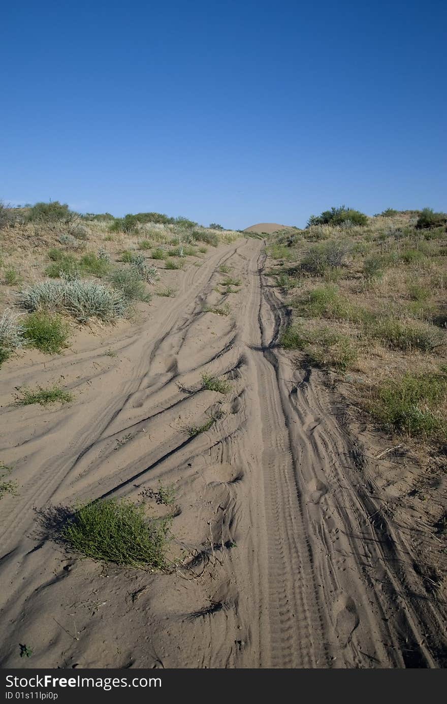 Road through the desert under a blue sky. Road through the desert under a blue sky