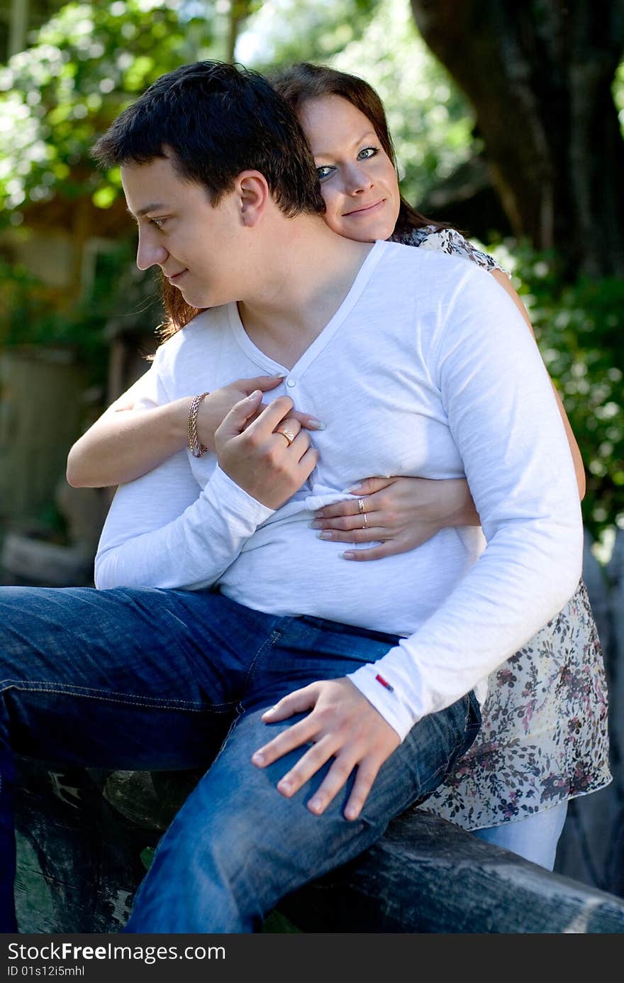 Woman with man sit on a tree to embrace each other. Woman with man sit on a tree to embrace each other