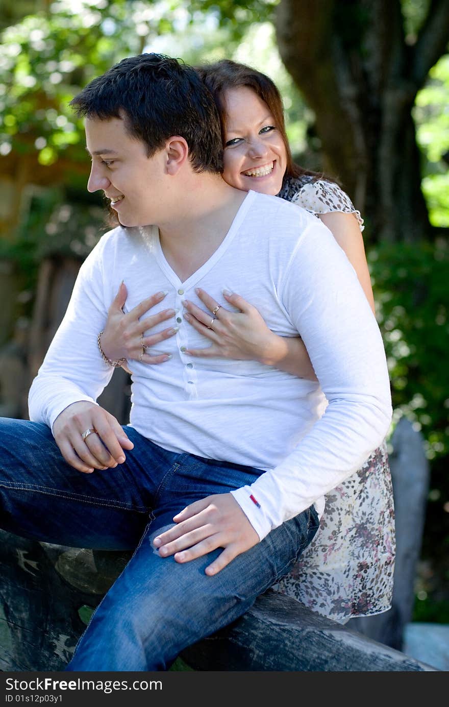 Woman with man sit on a tree to embrace each other. Woman with man sit on a tree to embrace each other